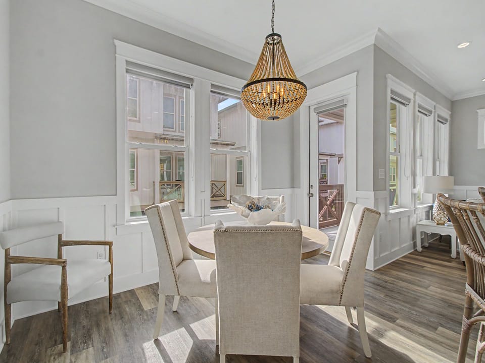 Dining area invites your family to relax around the round table with soft chairs and coastal decor accents