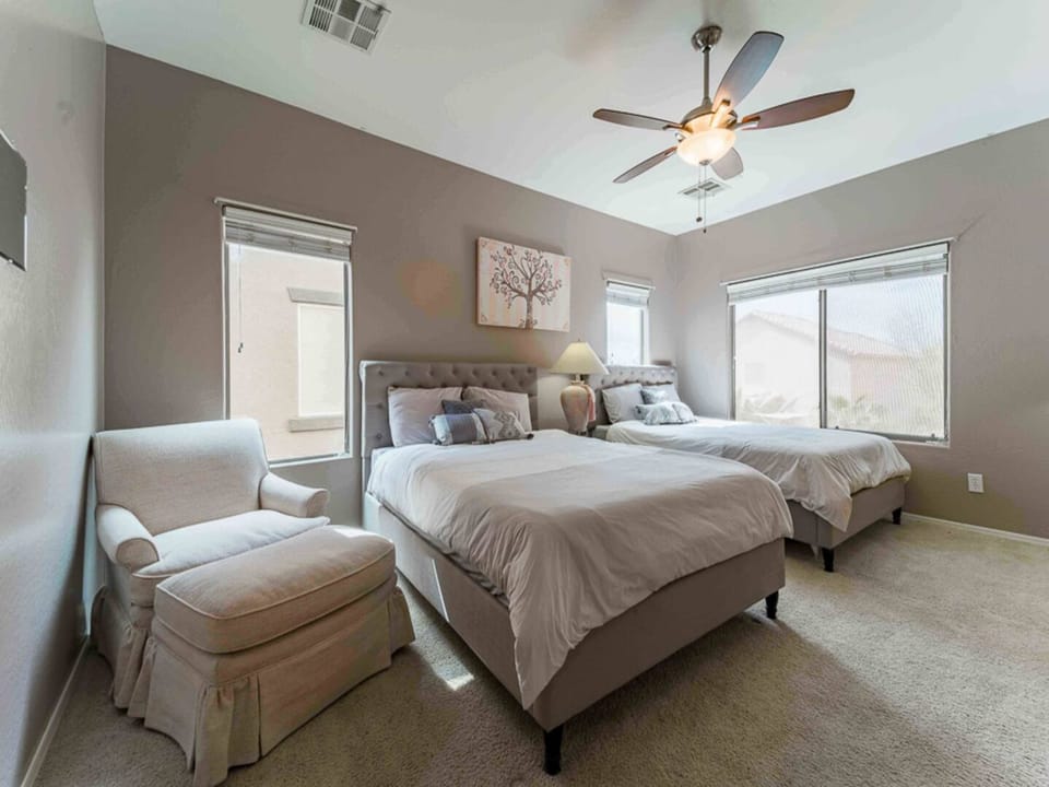 Comfortable bedroom with soft bedding, ceiling fan, and a calm relaxing feel.