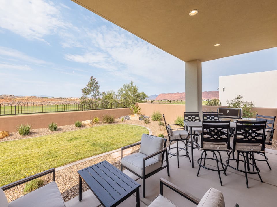 The enclosed private backyard offers stunning views of the red rock cliffs and lush golf course, along with a spacious patio and Weber Genesis grill for all your outdoor cooking needs.