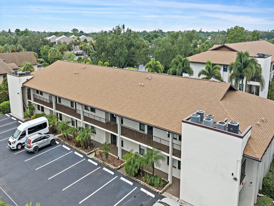 The property is nestled in a lush neighborhood with abundant greenery and palm trees, offering a peaceful setting with convenient on-site parking for guests.