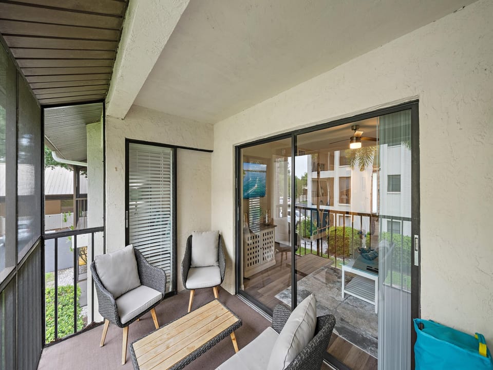Your private balcony offers a peaceful spot to unwind with comfortable seating and a view into your stylishly appointed living space. Natural light flows through the glass doors, creating a welcoming indoor-outdoor connection.