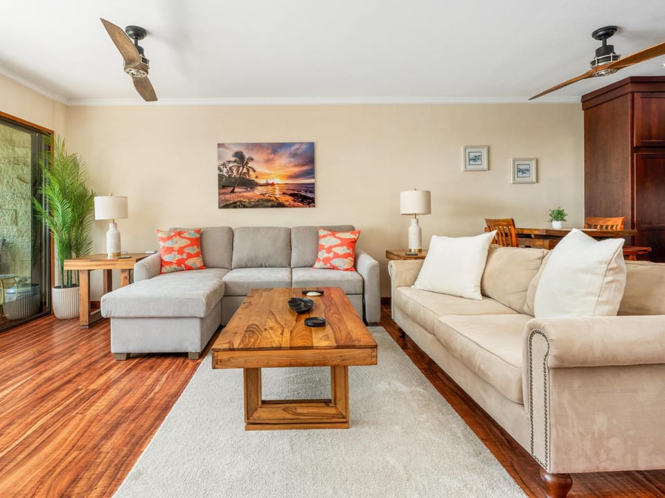 Sink into plush sofas and unwind in this warm living space, where rich wood floors and breezy coastal touches create your perfect home base.