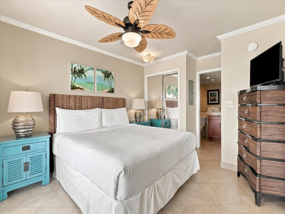 Drift off in this tropical Bedroom with ceiling fans, AC and crisp white linens to invite a restful night's sleep.