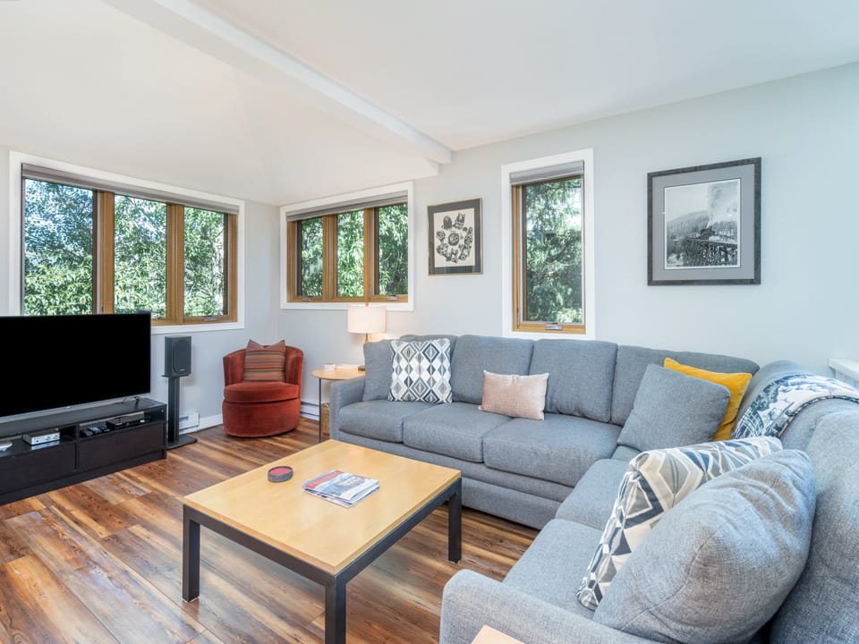 Sink into plush seating surrounded by bright windows that frame leafy views—your cozy retreat for unwinding after a day of exploring.