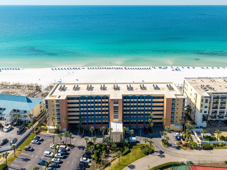 Beachfront resort positioned directly on pristine white sand beaches with crystal-clear turquoise waters stretching to the horizon.