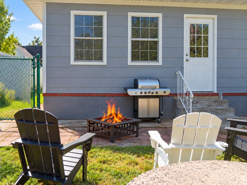 Private backyard patio with fire pit, grill, and cozy outdoor seating
