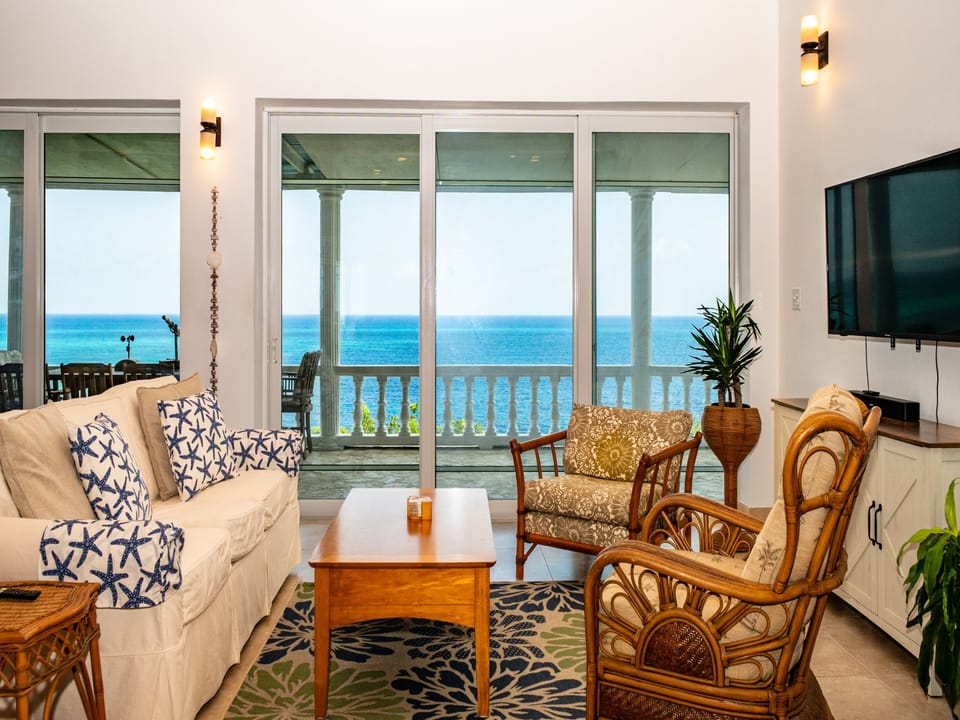 Atlantic-front great room with 50-mile view through a wall of glass overlooking the ocean.