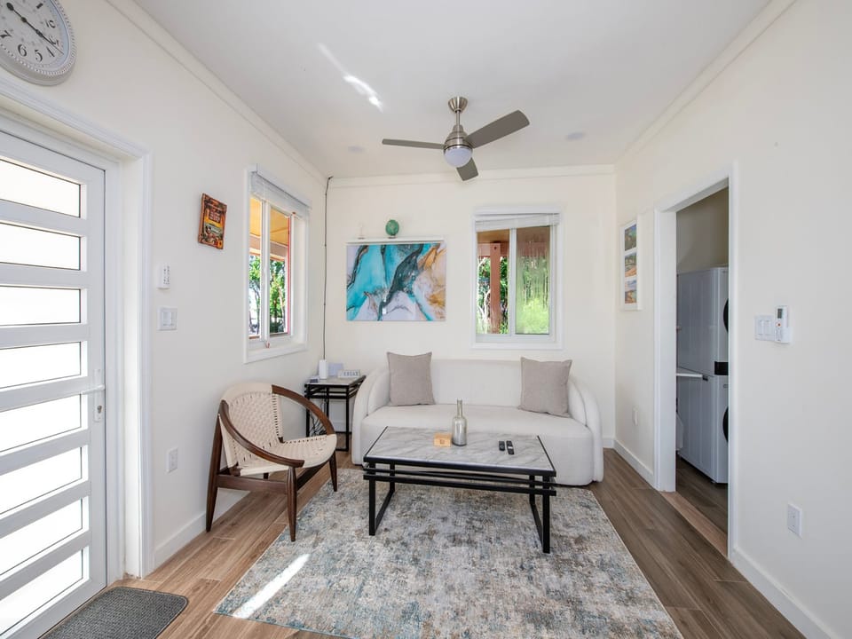 The living room is equipped with a wall-mounted flat screen smart TV and a sofa and chair.