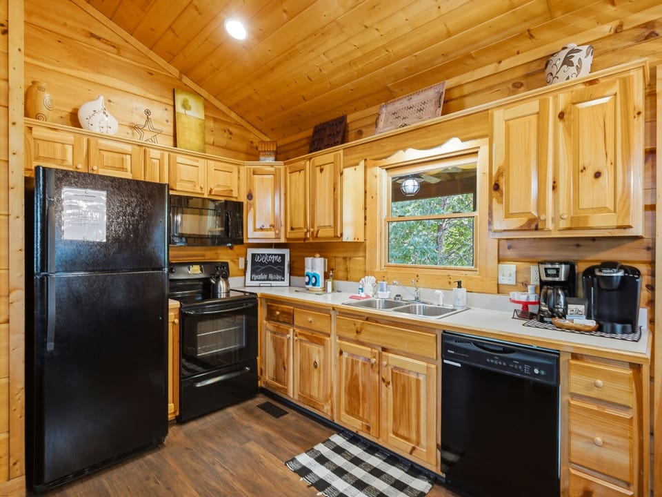 Your fully equipped kitchen makes meal prep a breeze, with warm wood cabinetry, modern appliances, and a view of the trees while you cook.