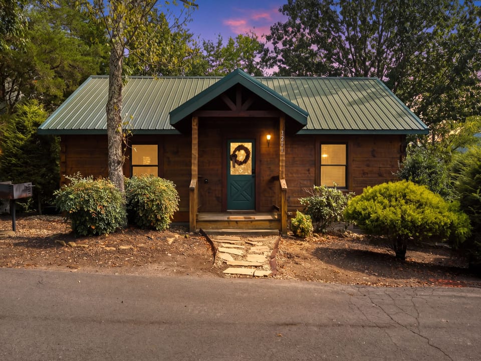 A charming cabin exterior nestled among towering trees, where warm light glows from the windows beneath a twilight sky painted in soft purples and pinks.