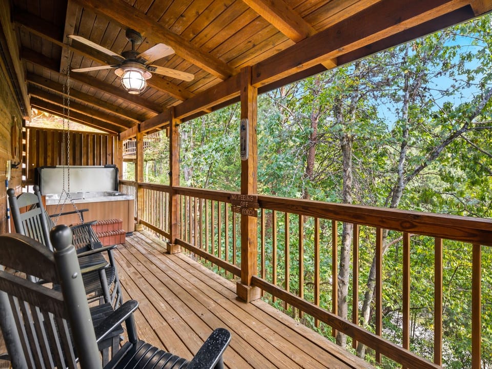Unwind on your private covered deck with a porch swing, rocking chairs, and a hot tub nestled among towering trees—your peaceful retreat surrounded by nature.