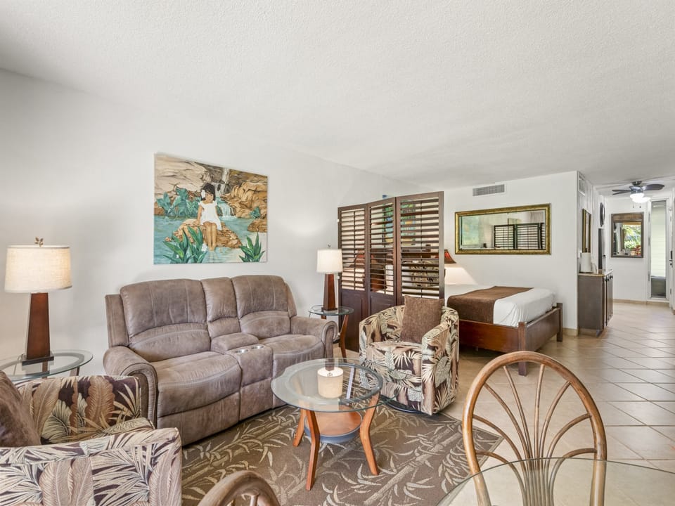 Settle into your tropical retreat—open floor plan connects cozy living space with bedroom, accented by island artwork and warm wood tones.
