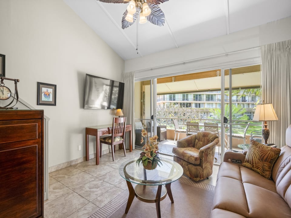 Step into your bright living room with comfortable seating, a flat-screen TV, and tropical-style ceiling fan. Sliding glass doors open to your private balcony overlooking lush grounds.