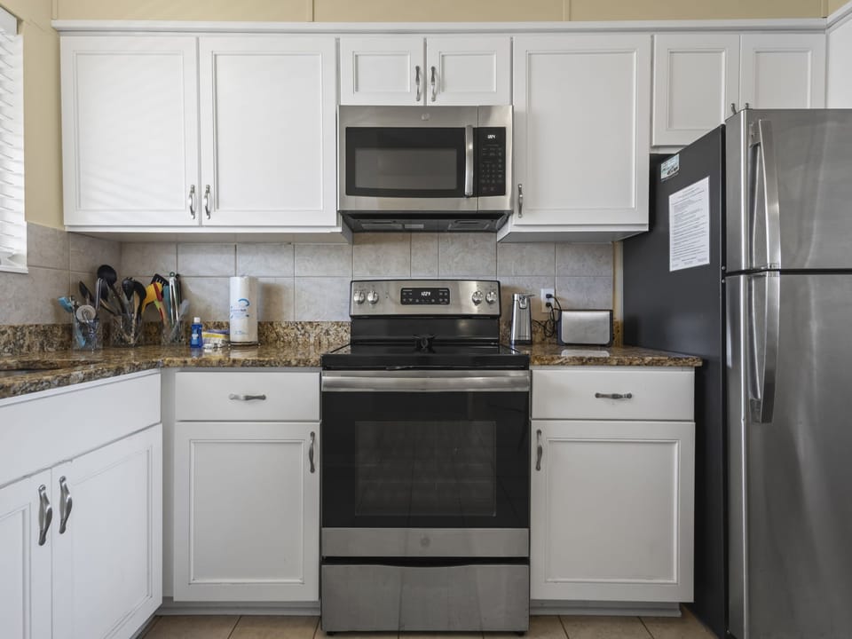 The open kitchen design offers stainless appliances, granite countertops, and is fully stocked with all items needed for preparing your meals.