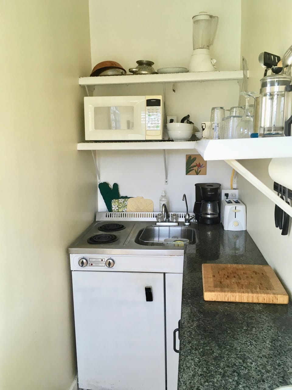 Galley kitchen with stove top, microwave oven, refrigerator and other amenities.
