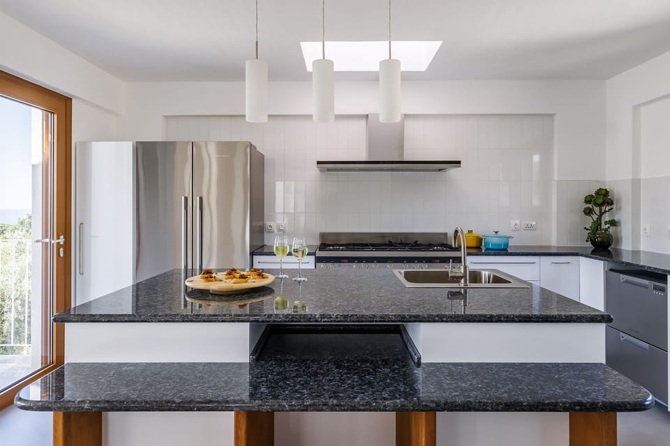 Well equipped kitchen with skylight. Kitchen island has blue pearl granite top.