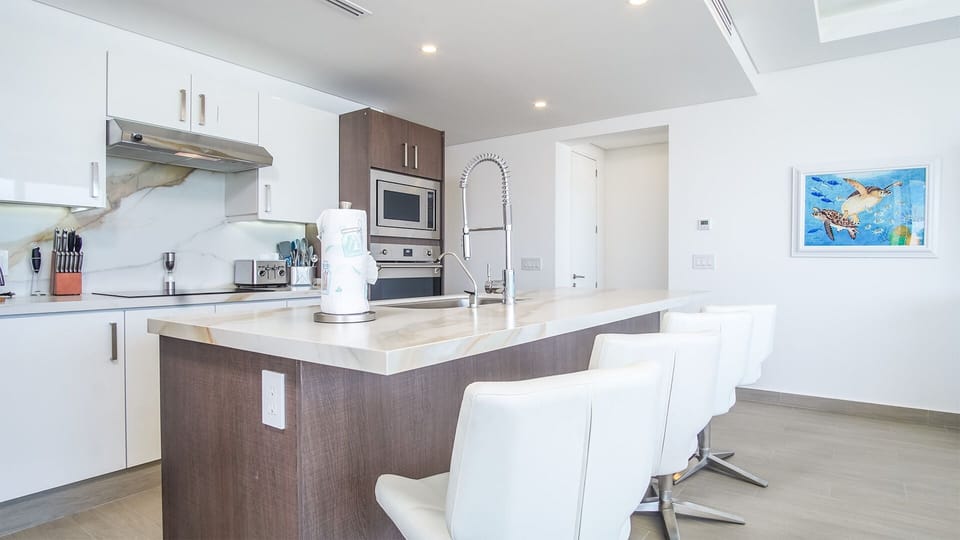 Upholstered chairs line the kitchen island counter.