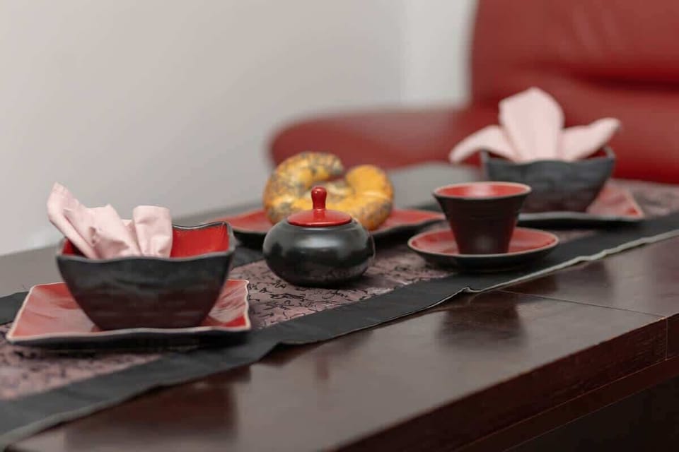A decorative tea set on a dark wooden table, adding an elegant touch to the living area.
