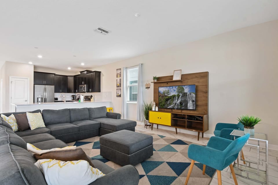 Relax in style with this cozy lounge, smart TV, and sleek modern kitchen nearby.