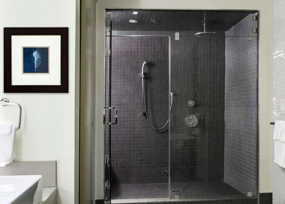 Refresh under a sleek rain shower in modern tile.