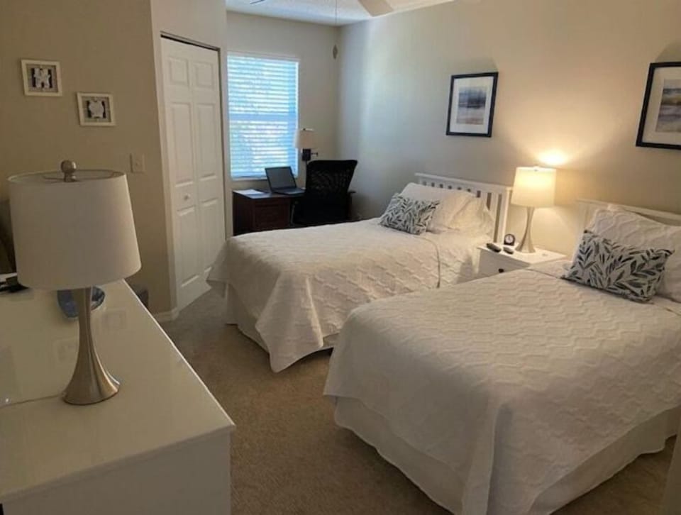 Guest bedroom with desk and TV
