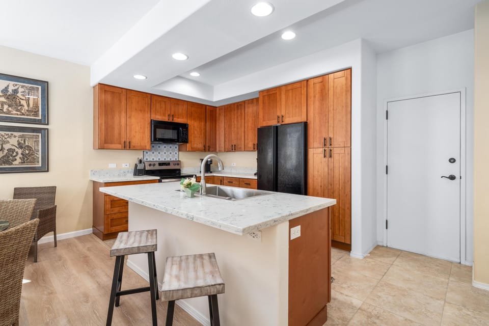 Full kitchen with breakfast bar, granite counters, and modern appliances