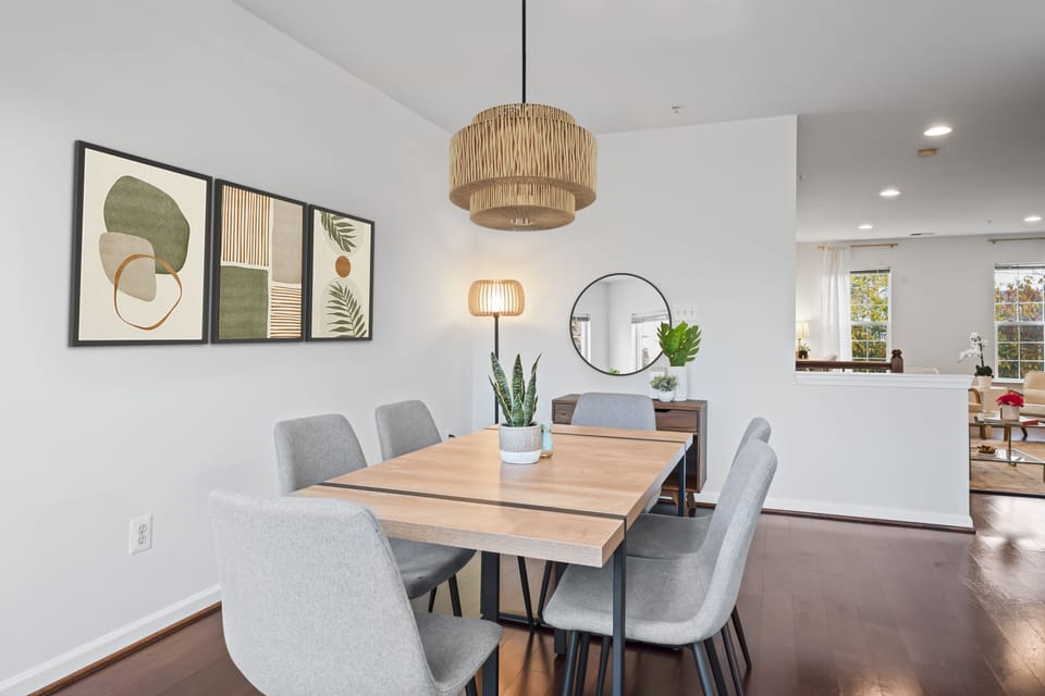 Modern dining space with nature-inspired art, cozy chairs, and minimalist decor.