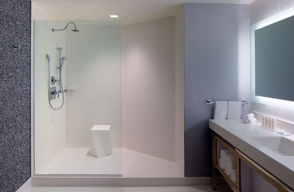 Refresh under a rainfall shower in a sleek spa setting.