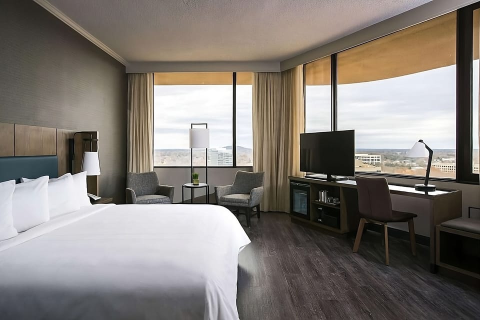 Relax into crisp linens beside corner windows and city views.