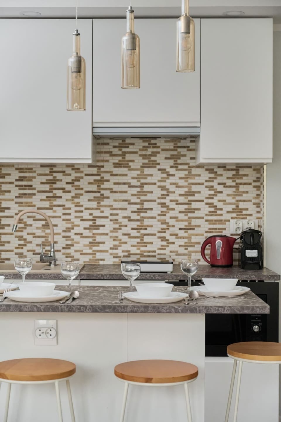 Another angle of the kitchen, featuring a bar-style counter with stools and warm lighting.
