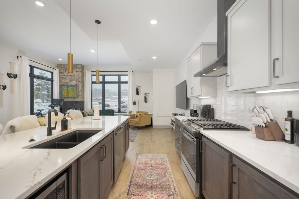 Your gourmet kitchen flows seamlessly into the living space, featuring marble countertops, premium appliances, and cozy fireplace views.