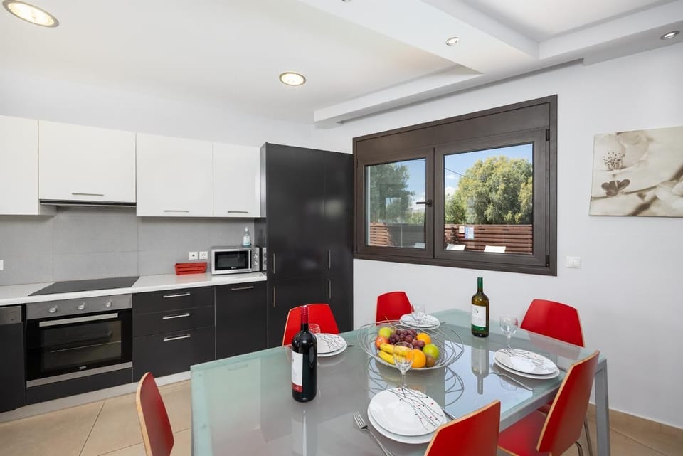 Open-plan living room with sofa, dining area, kitchen, ornamental fireplace, A/C, WiFi internet, and satellite TV