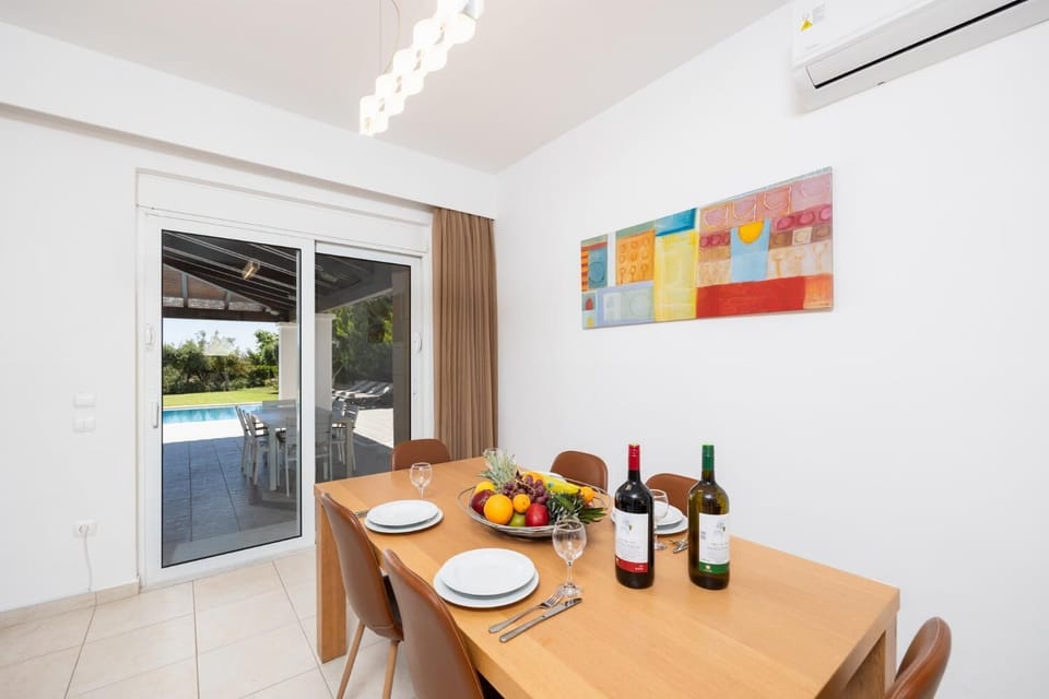 Open-plan living room with sofas, dining area, kitchen, A/C, WiFi internet, and satellite TV