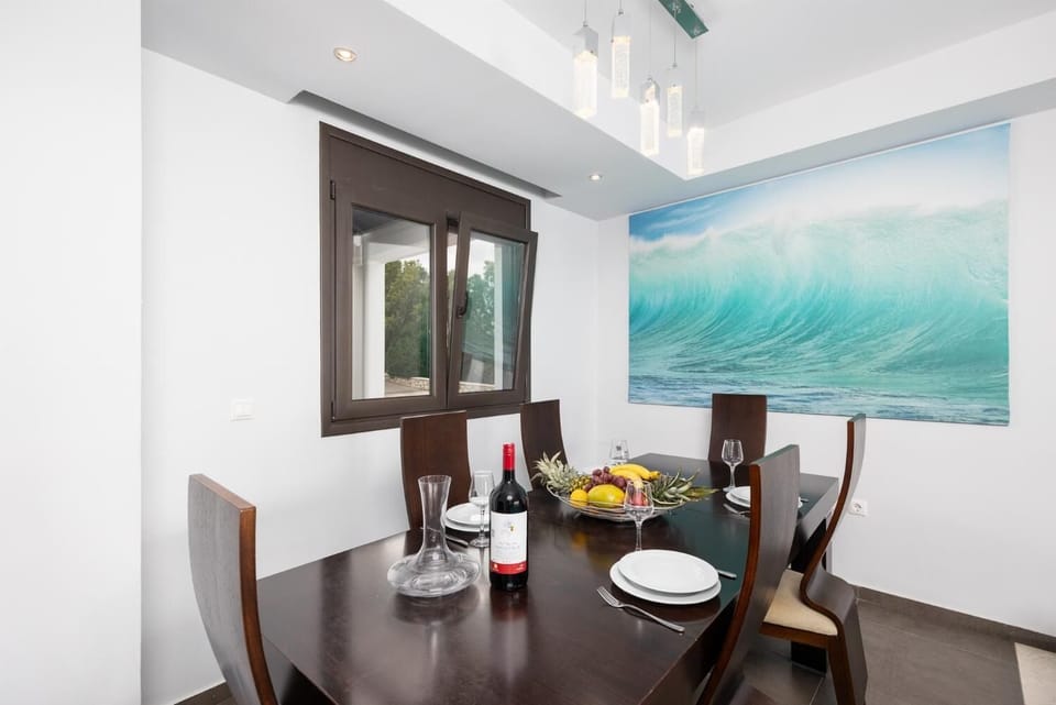 Open-plan living room with sofas, dining area, kitchen, ornamental fireplace, A/C, WiFi internet, satellite TV, and sea views