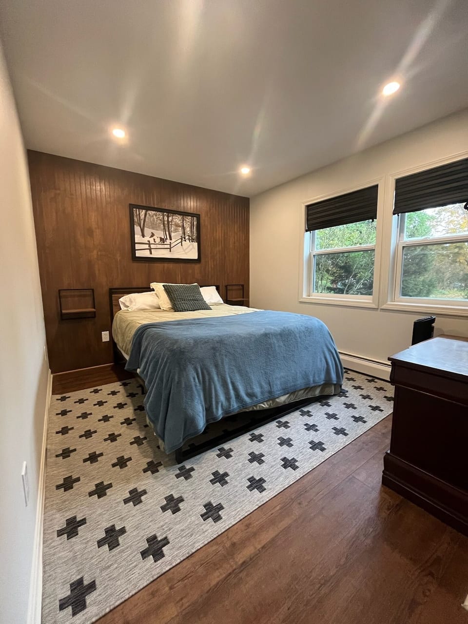 Front bedroom with queen bed, side tables, hanging bar for clothes, luggage rack