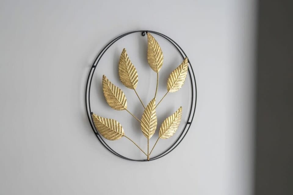A decorative metal wall piece with leaves, adding an artistic and natural element to the bedroom wall.