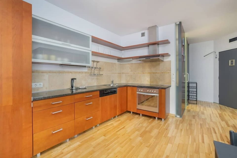 Spacious kitchen with wood cabinets and a dining area, providing a warm and inviting setup for cooking and dining.