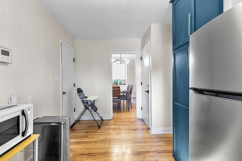 Your modern kitchen features sleek blue cabinetry and stainless steel appliances, creating a stylish cooking space that flows seamlessly into the dining area.
