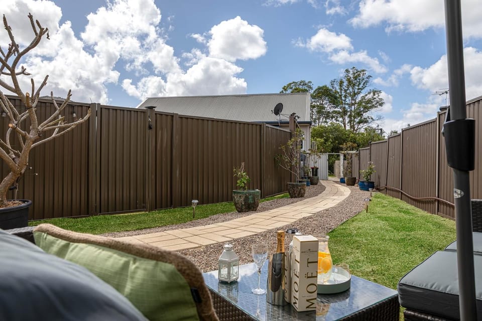 A spacious, fully fenced private yard with outdoor seating. 