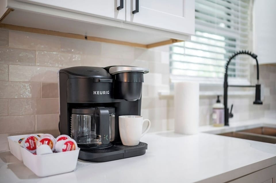 A Keurig, pods, creamer and sugar are provided.