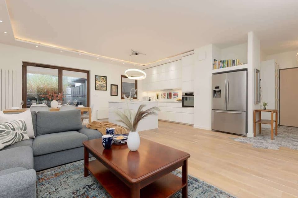 A spacious living room with a comfortable sofa, wooden coffee table, and modern decor.
