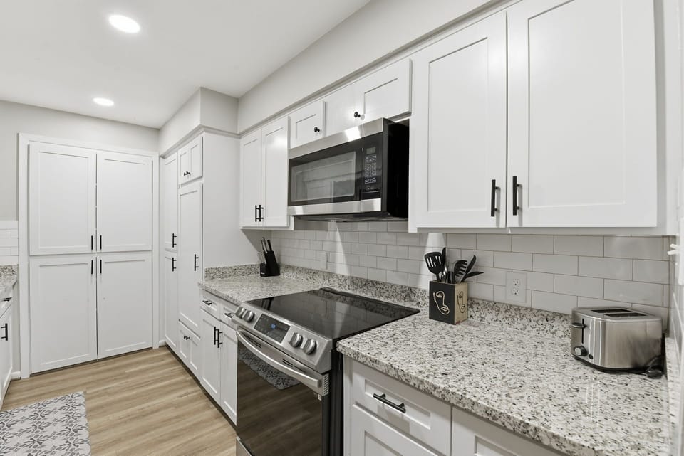 Kitchen has an electric stove & oven, microwave, pots & pans, plenty of counter space & storage, & some spices. 