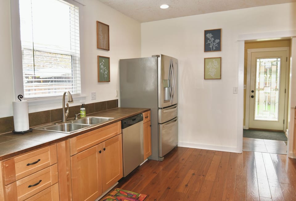 Large Kitchen leads to Laundry room with back door to Deck & Fire pit. 