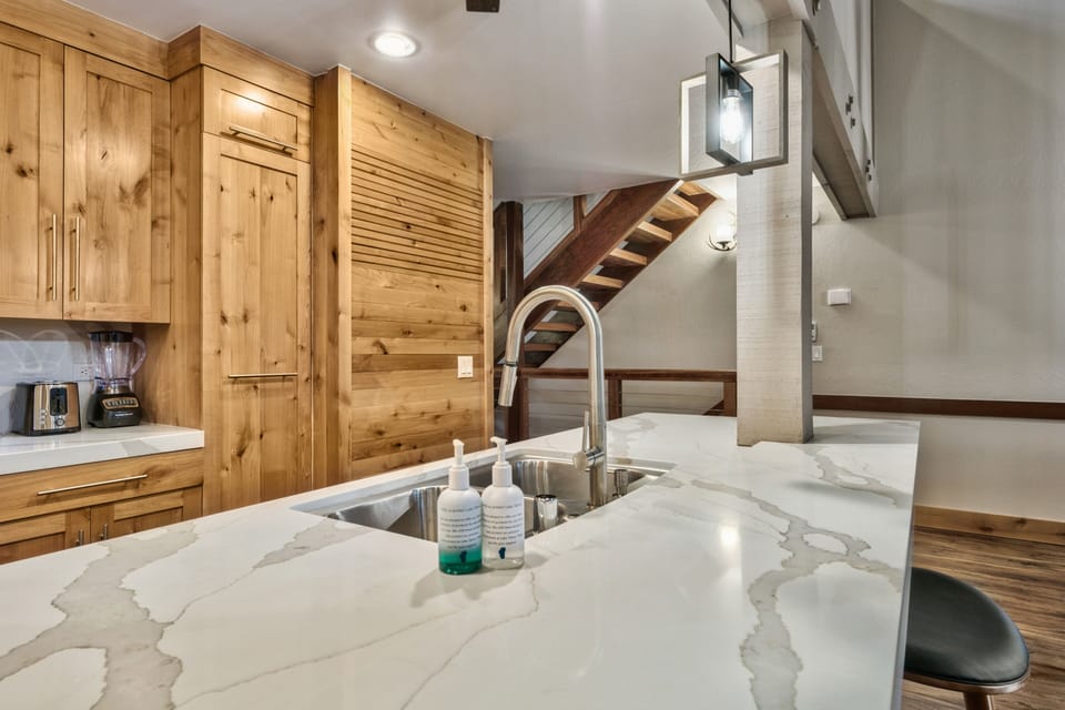 Your gourmet kitchen features stunning marble countertops and warm wood cabinetry, creating the perfect space for cooking memorable meals during your stay.