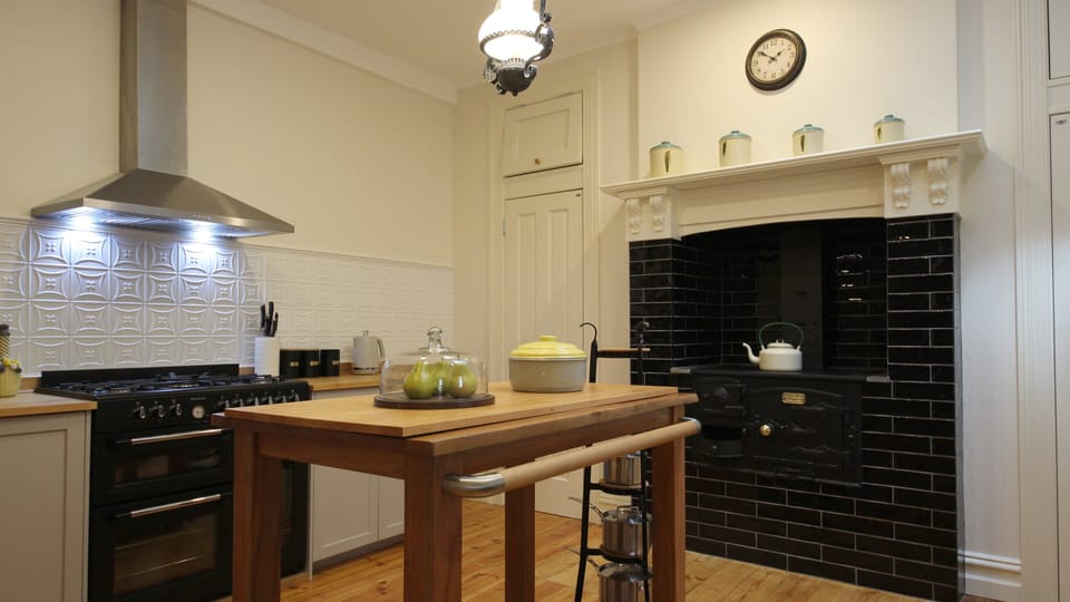 Farmhouse style kitchen with gas cooker and featuring antique wood fired cooker