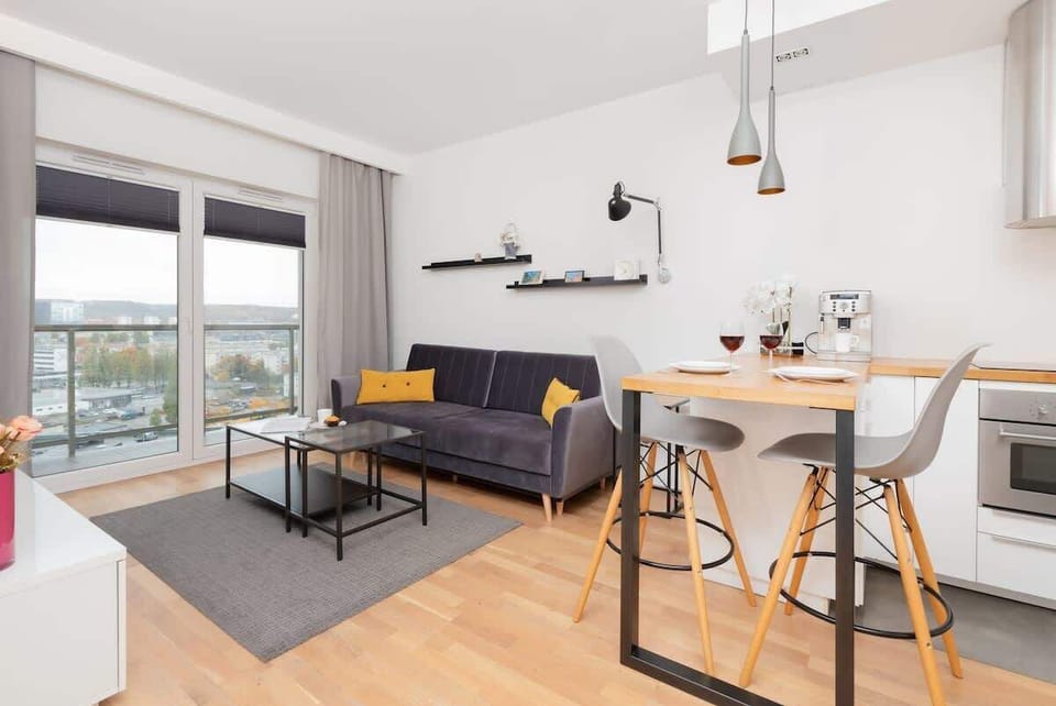 Bright living room with city views – Light-filled space with floor-to-ceiling windows and a comfortable layout.