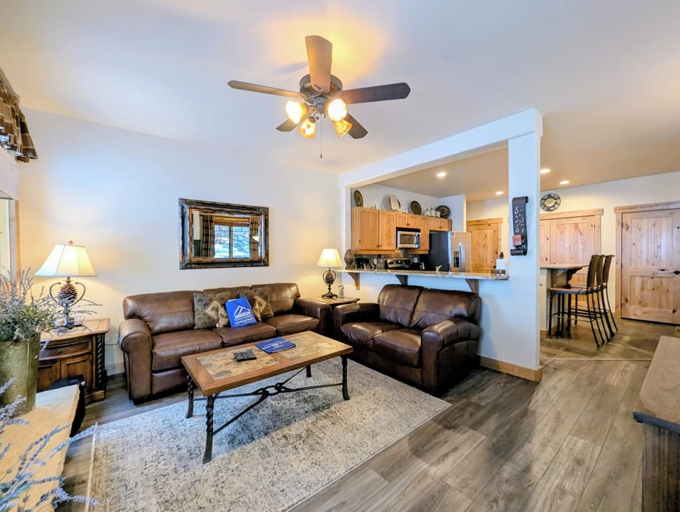 Settle into rich leather sofas in your spacious living area, where warm wood finishes create the perfect mountain retreat atmosphere for relaxing.