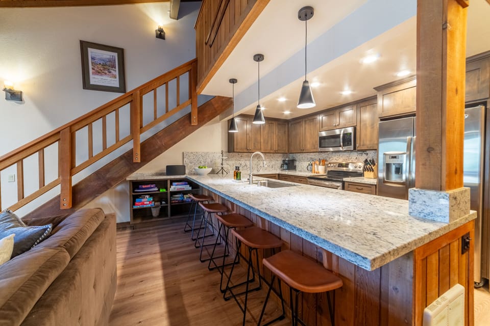 The spacious open kitchen includes five barstools, providing ample seating.