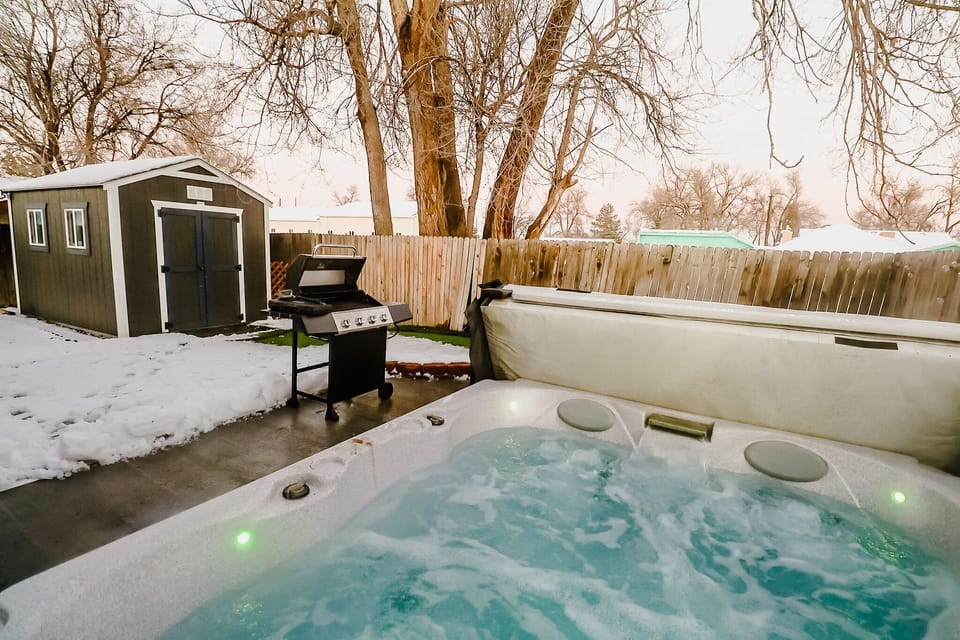 An inviting outdoor retreat boasting both a soothing Jacuzzi and a modern BBQ grill, perfect for relaxation and entertaining under the open sky