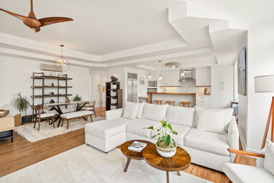 Step into an expansive living space, where modern furnishings seamlessly blend with wooden touches, offering the ideal ambiance for a cozy getaway.
